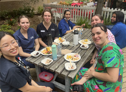 workers sitting round a table with food on plates