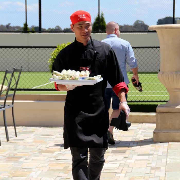 Flying Woks chef serving canapés at an upscale birthday venue