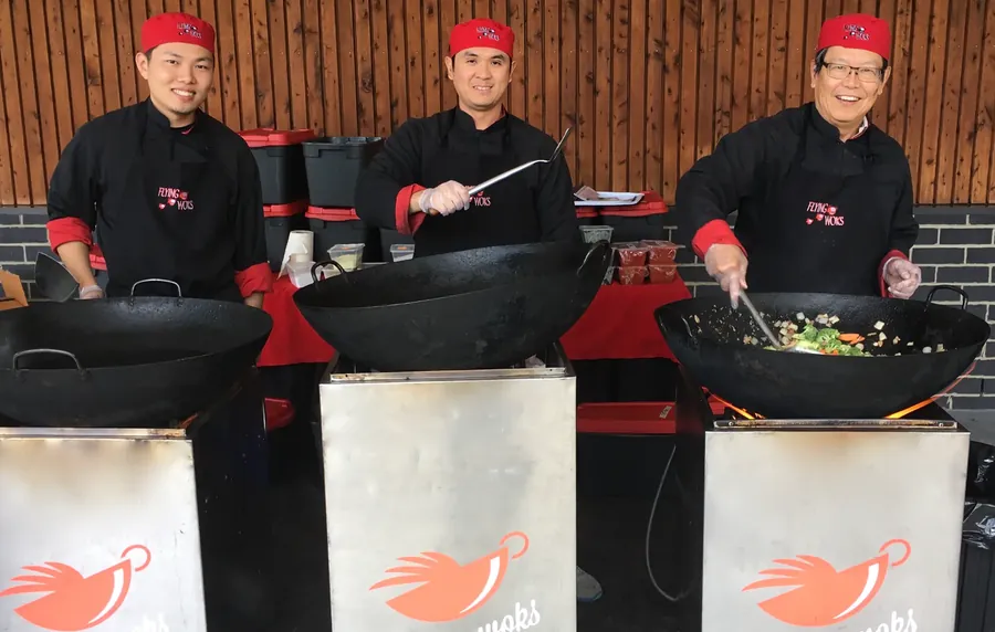 Three Flying Woks chefs ready to cook at a private party