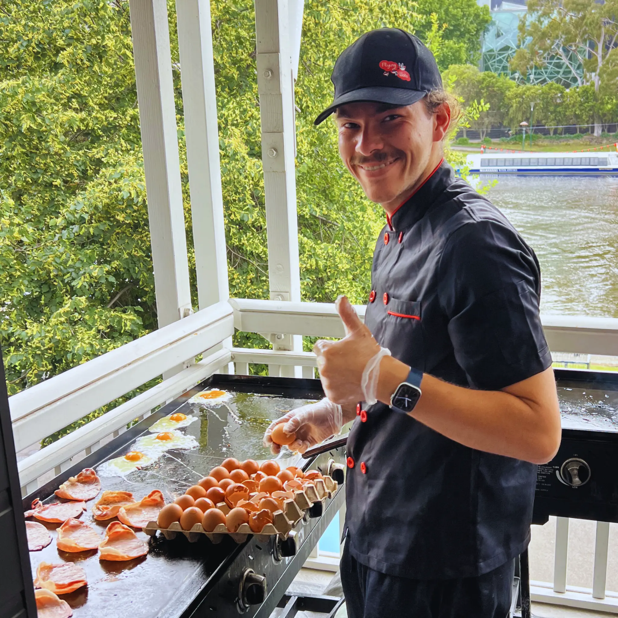 Flying Woks chef cooking bacon and eggs live on BBQ at Melbourne breakfast catering event