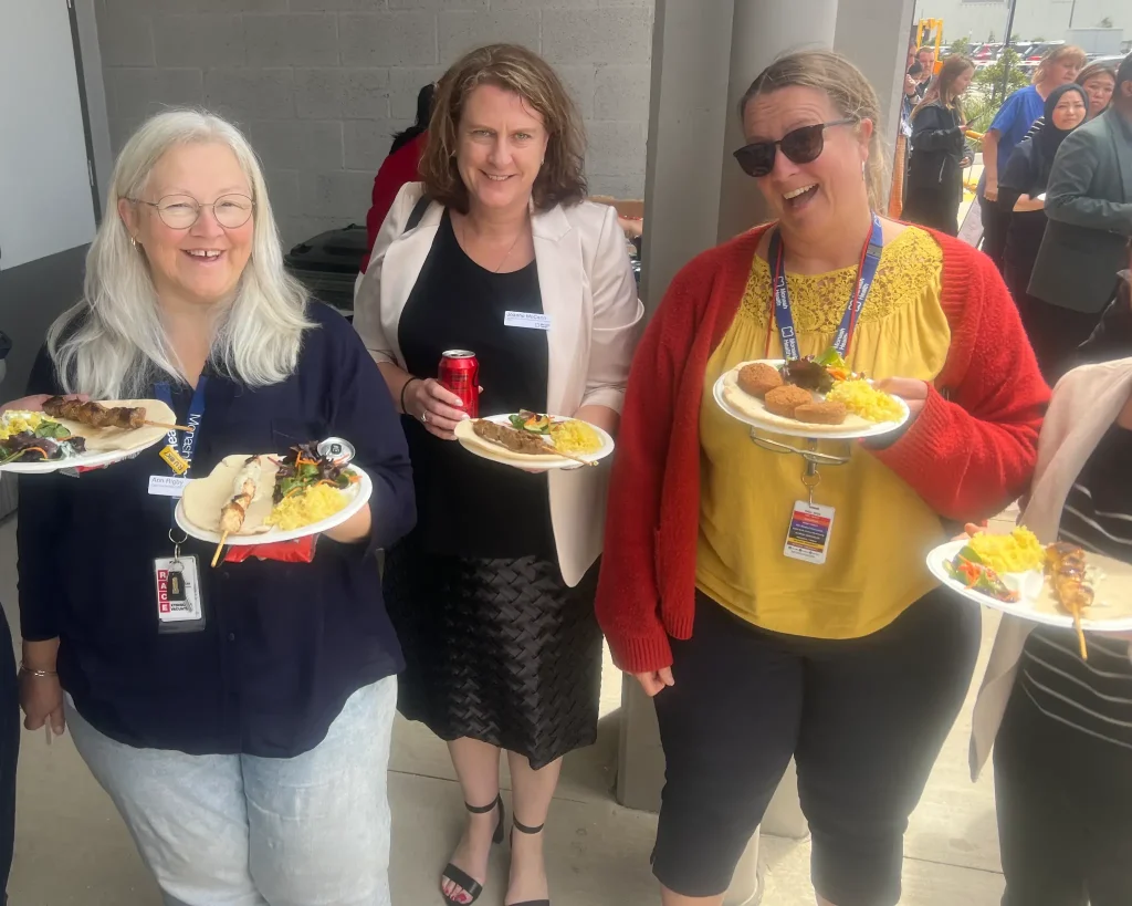 Corporate guests enjoying Middle Eastern shish kebab plates at a Flying Woks catered event