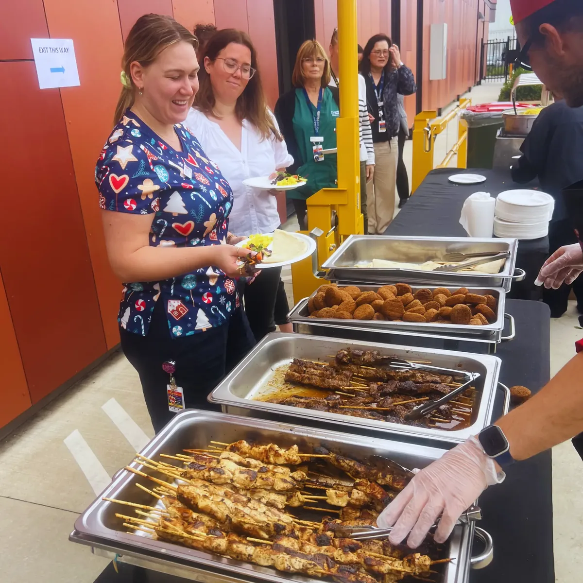Monash Health staff being served Middle Eastern catering at their Christmas party by Flying Woks