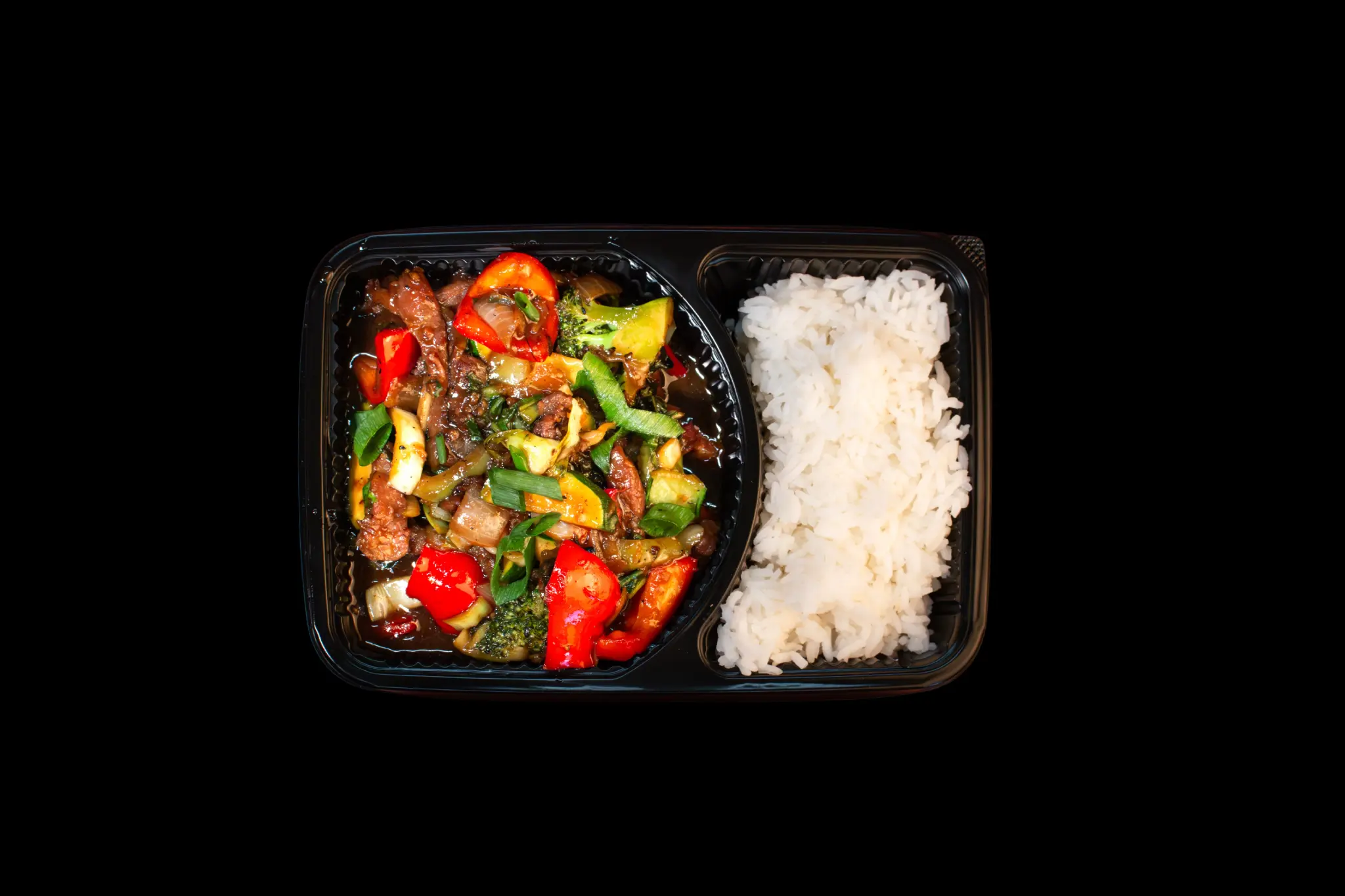 Flying Woks beef stir fry with rice in premium black meal tray — overhead view corporate catering