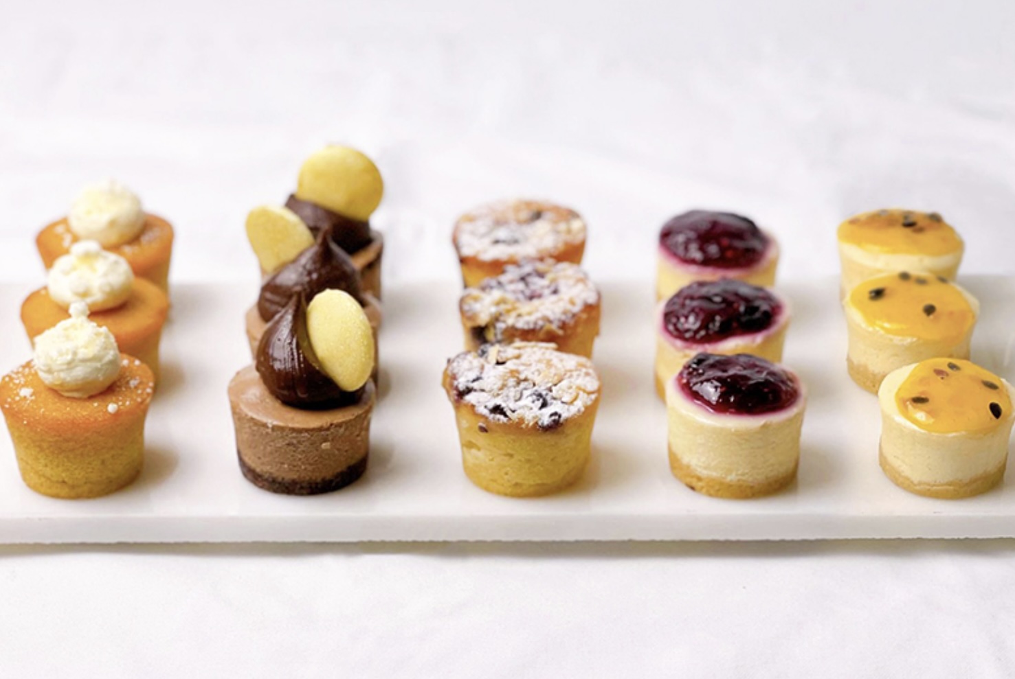 Selection of colourful mini cheesecakes on a catering platter